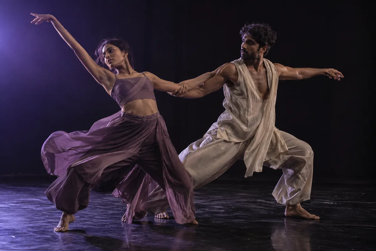 Indian contemporary dancers moving in a duet on stage